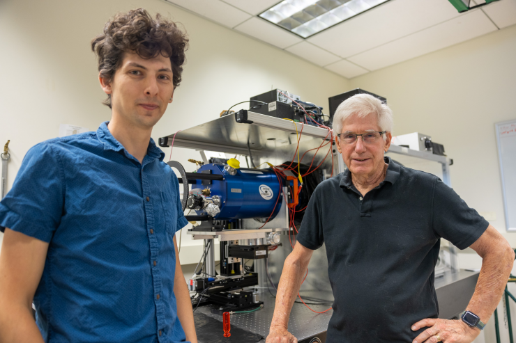 Tyson, on the right, stands with graduate student Dan Polin, on the left, in the optical simulator lab. (Photo by Greg Watry/UC Davis)